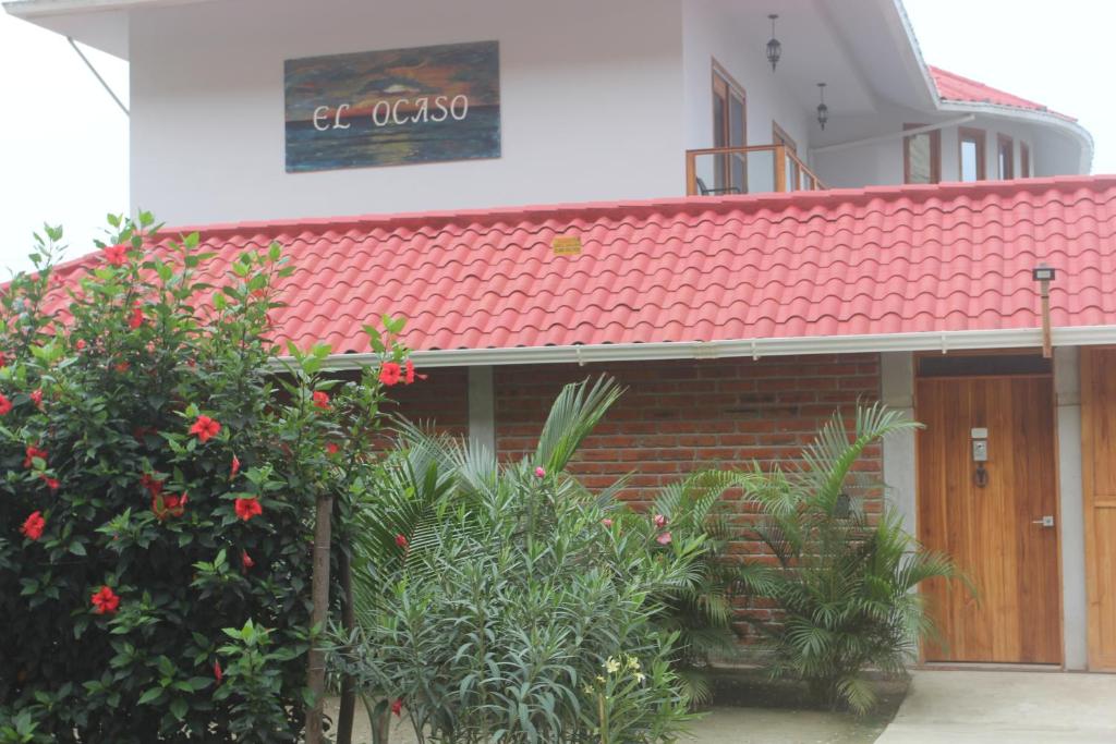 卡诺阿El Ocaso的一座有红色屋顶和一些植物的建筑