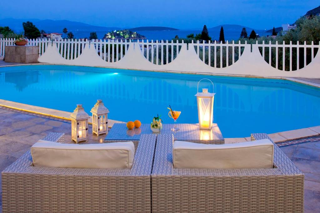 托隆维瑞斯公寓酒店的游泳池设有2把藤椅和1张带台灯的桌子