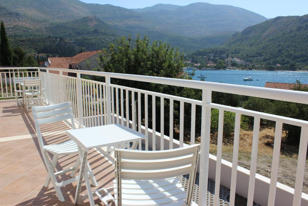 斯拉诺Apartments Villa Eva的阳台配有桌椅,享有山景。