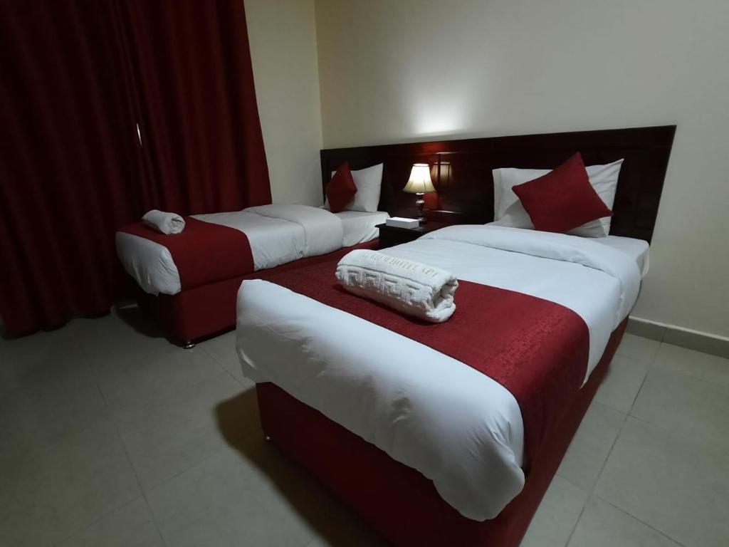 沙迦Al Reem Hotel Apartments的酒店客房,设有两张床和一张沙发