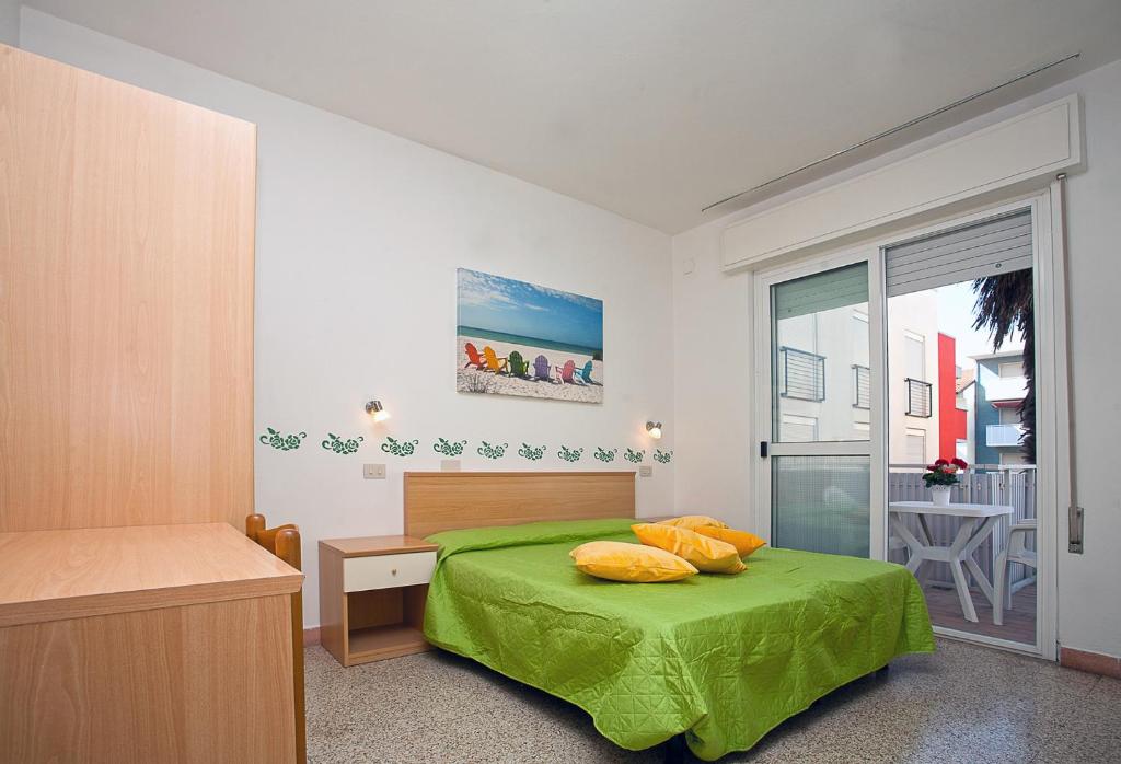 利尼亚诺萨比亚多罗Hotel Amalfi & Dépendance的一间带绿色床的卧室和一个阳台