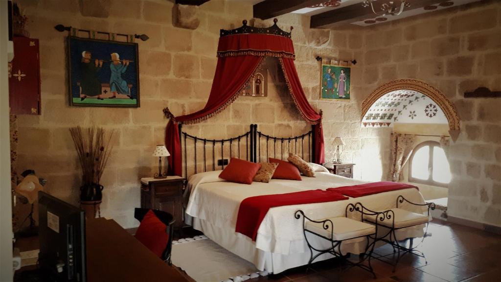 Baños de Rioja托雷富尔特S.XIII中世纪乡村旅馆的一间卧室配有一张红色天蓬大床