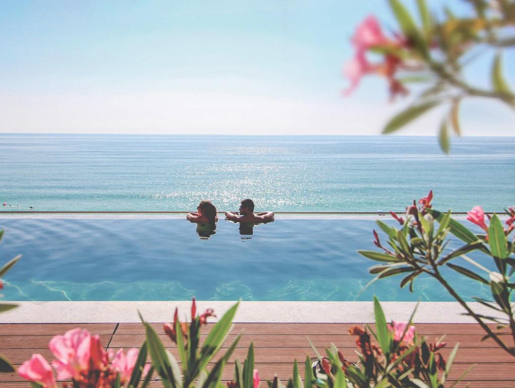 金沙GRIFID Encanto Beach Hotel - MediSPA, Ultra All Inclusive & Private Beach的两个孩子坐在游泳池的水里