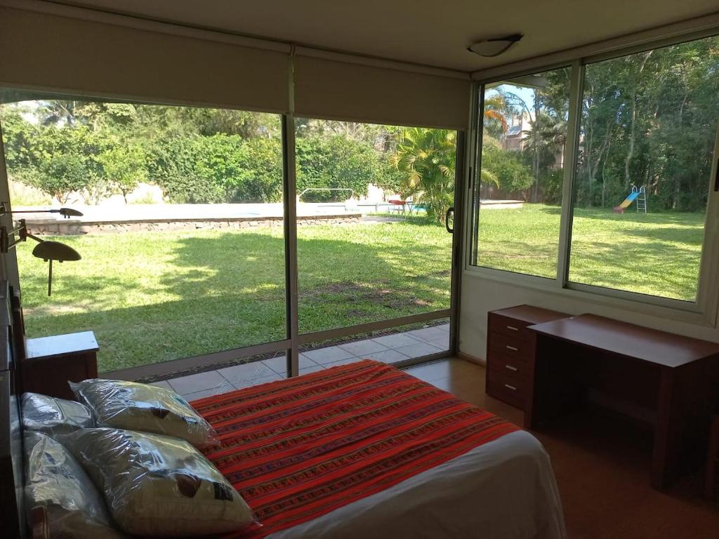 波萨达斯Parana Riverside Guest House - Posadas的一间卧室设有一张床和一个大窗户