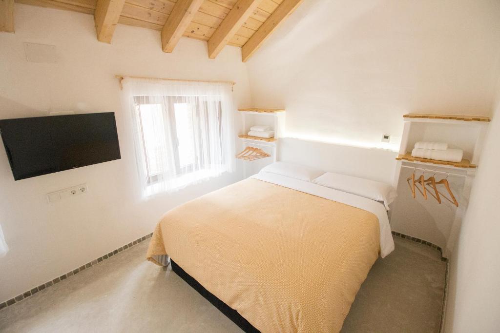 马海尔赖奥El Pequeño Pajar的一间白色卧室,配有床和电视
