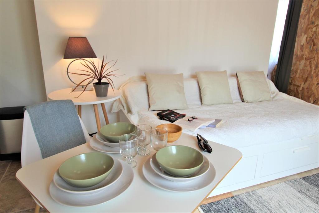 索尔格河畔利勒Les Bastidons de l'Isle - Le Saumane - 3 étoiles的客厅配有带盘子和玻璃杯的桌子