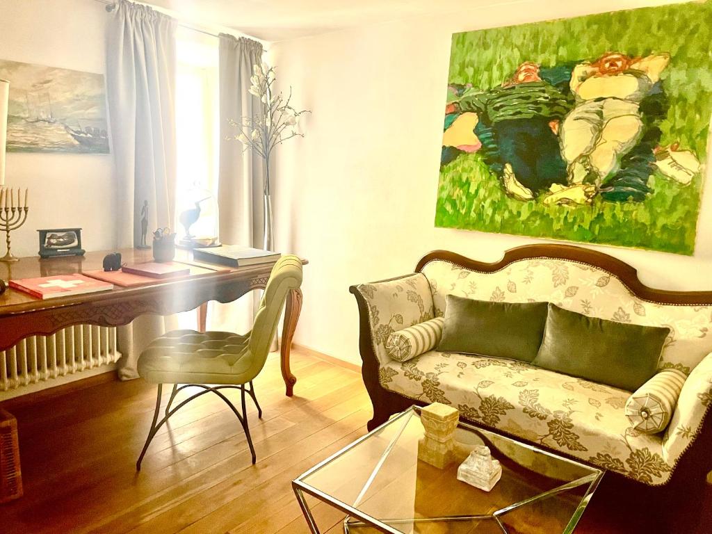 卡斯拉诺Elegantes Haus in der Altstadt Caslano的客厅配有沙发、书桌和绘画作品