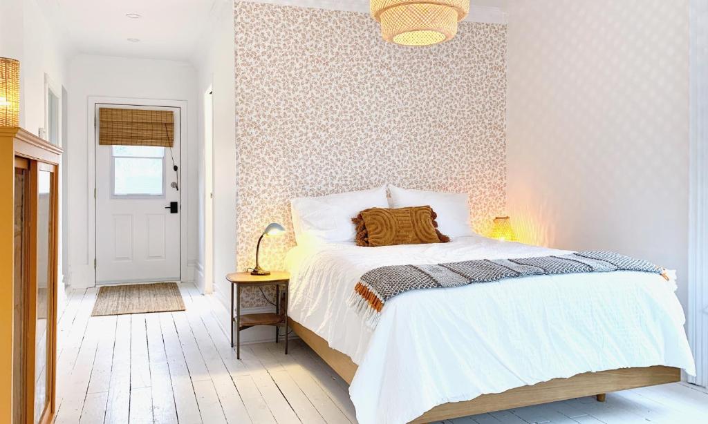 惠灵顿Flats South的卧室配有白色床和图案墙