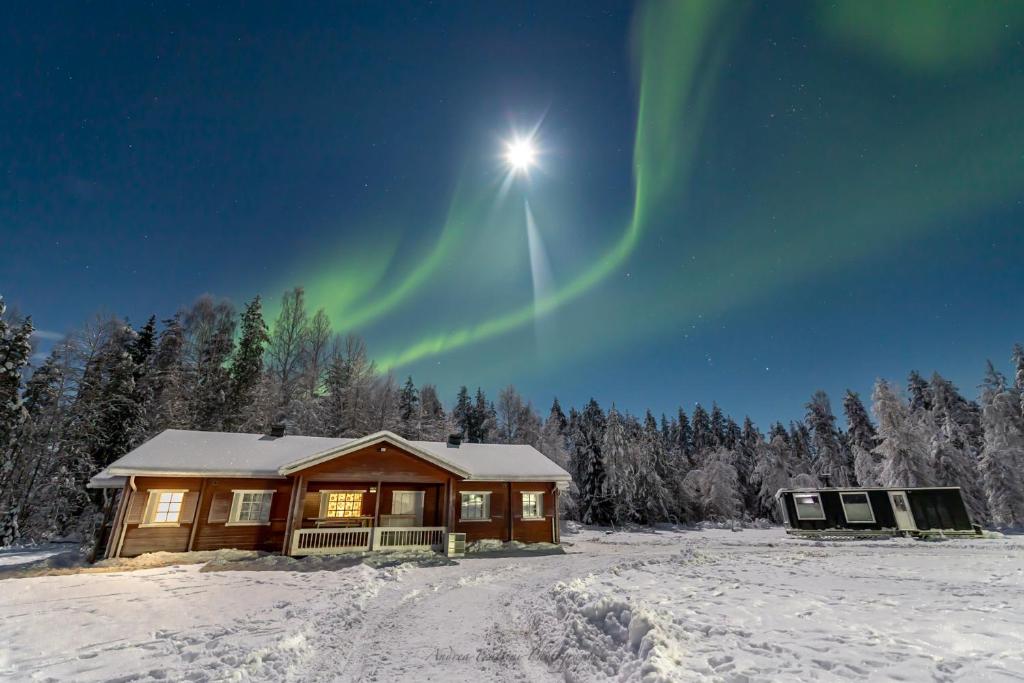 SompujarviOld Pine Husky Lodge的天空中光明的小木屋