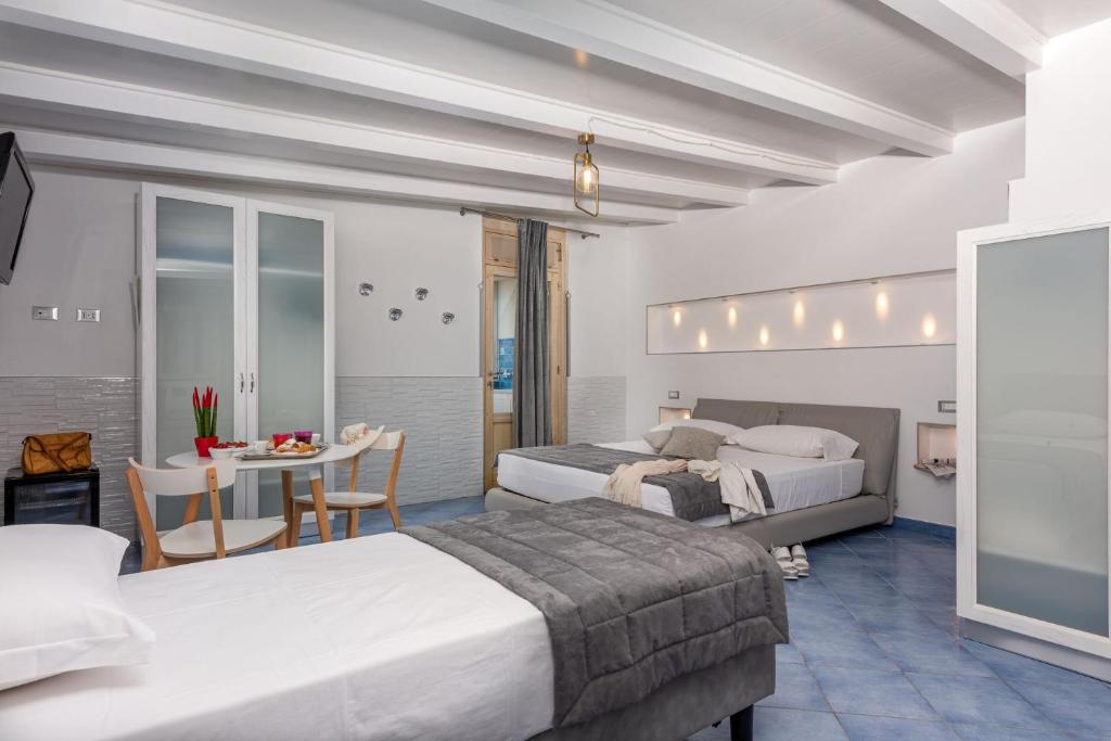 圣维托罗卡波Albert Rooms & Breakfast的酒店客房设有两张床和一张桌子。
