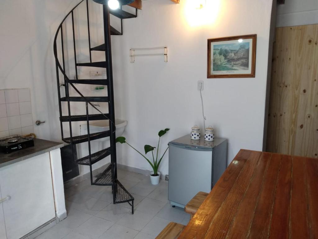 乌拉圭河畔康塞普西翁Duplex en el centro de Concepción del Uruguay的一个带桌子的厨房内的螺旋楼梯
