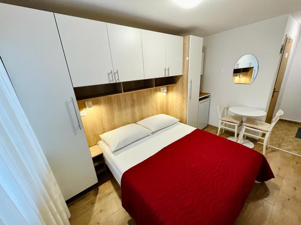 科尔丘拉克鲁尼克旅馆的卧室配有红色和白色的床和桌子