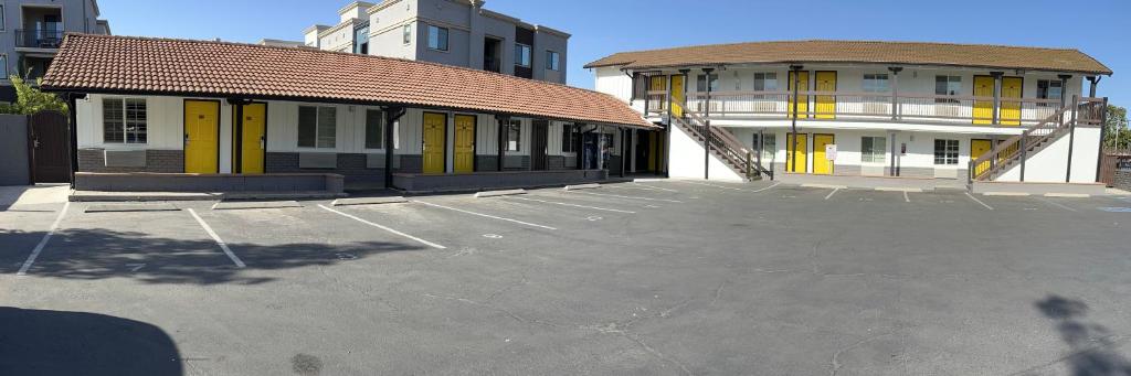 埃斯孔迪多埃斯孔迪多汽车旅馆的建筑前的停车场,有黄色门