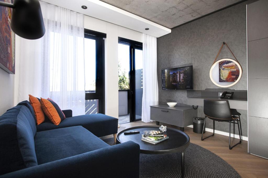 开普敦Bridgewater Apartments by Century City Hotels的客厅配有蓝色的沙发和桌子