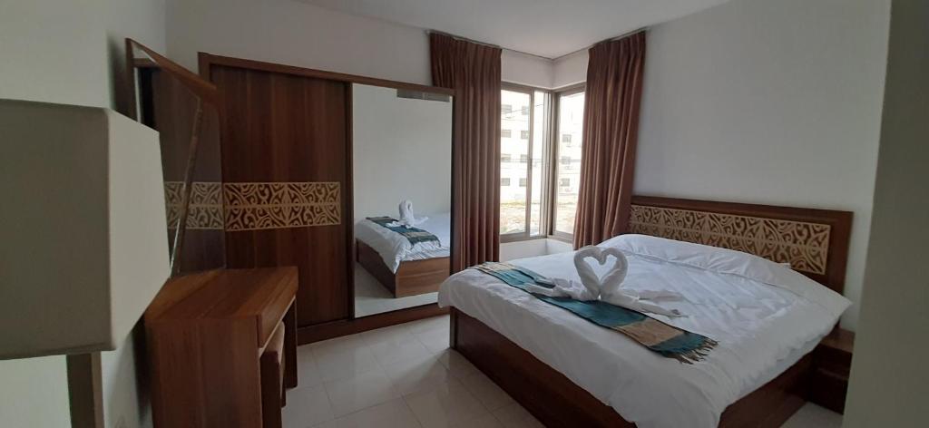 安曼Furnished Apartments Near McDonald's Al-Madina Al-Monawara St的一间卧室配有一张床和一面大镜子