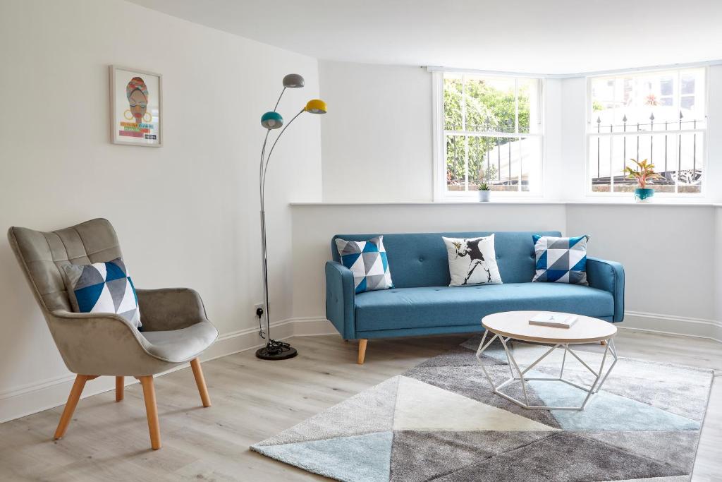 布里斯托Stylish, spacious flat with private parking的客厅配有蓝色的沙发和椅子