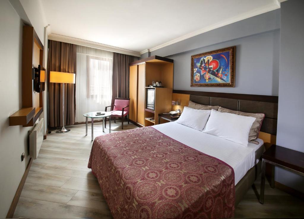巴勒克埃西尔爱利特阿霞酒店的酒店客房设有一张大床和一张桌子。