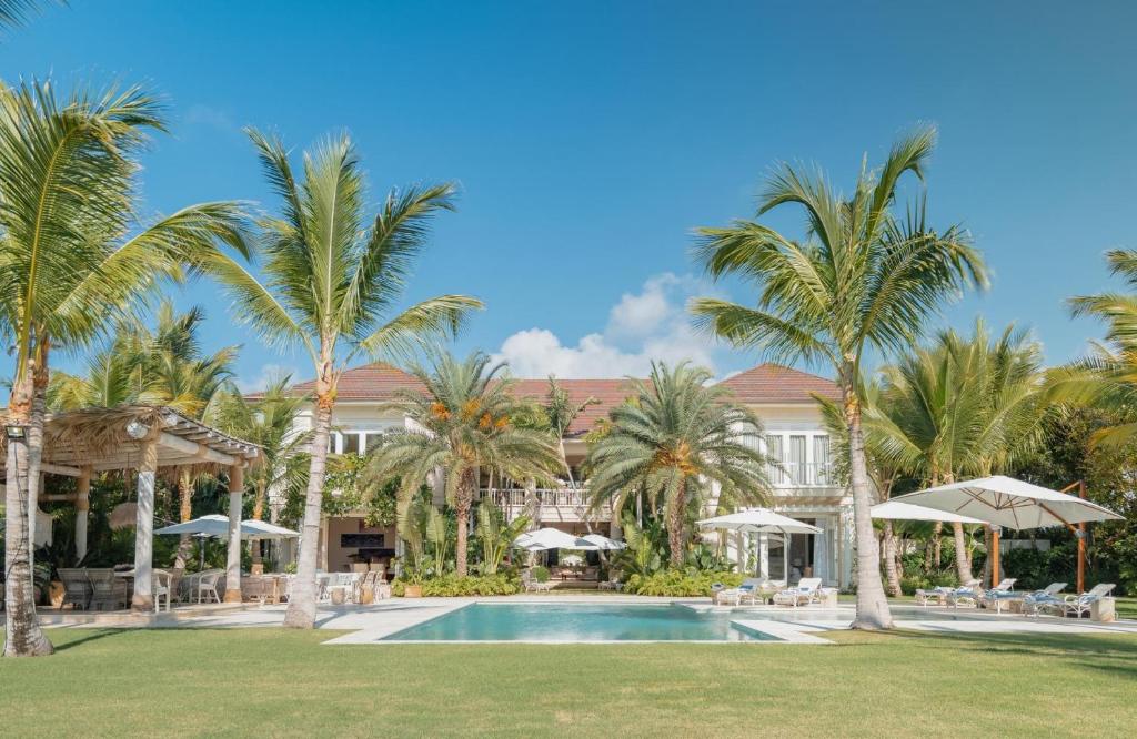 蓬塔卡纳Luxurious fully-staffed villa with amazing view in exclusive golf & beach resort的一个带游泳池和棕榈树的度假村