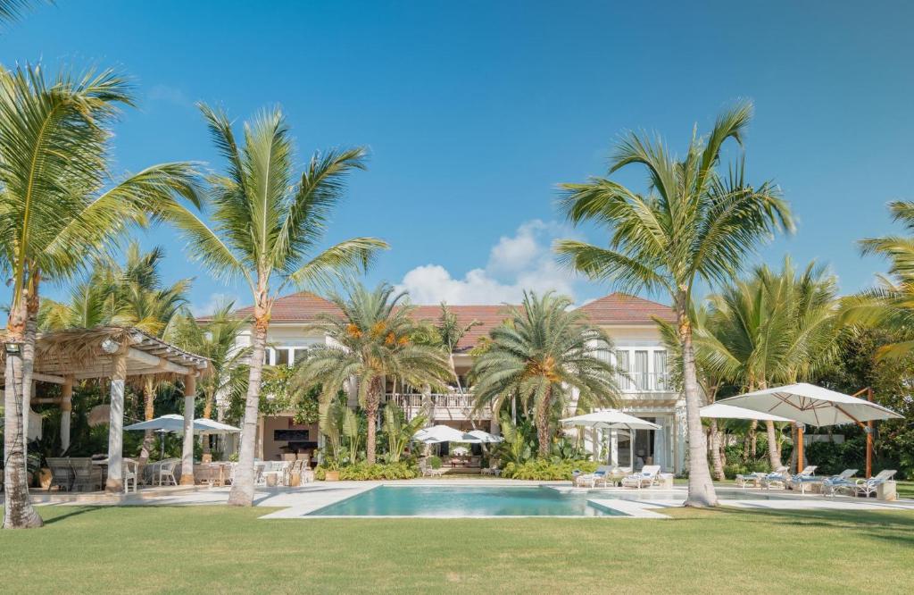 蓬塔卡纳Unique lake-front 10-bedroom mansion in most luxurious resort of the caribbean的一个带游泳池和棕榈树的度假村