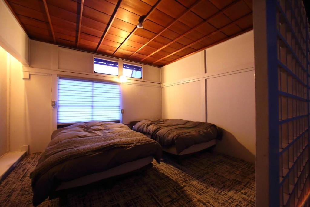 宫岛HEM'S HOTEL 1日1組限定 new的一间卧室设有两张床和木制天花板