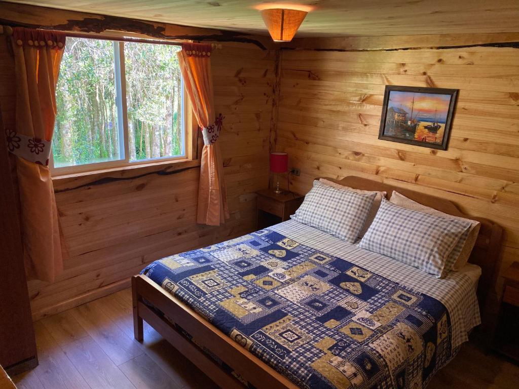 卡斯特鲁Cabañas Los Fabianes的小木屋内一间卧室,配有一张床