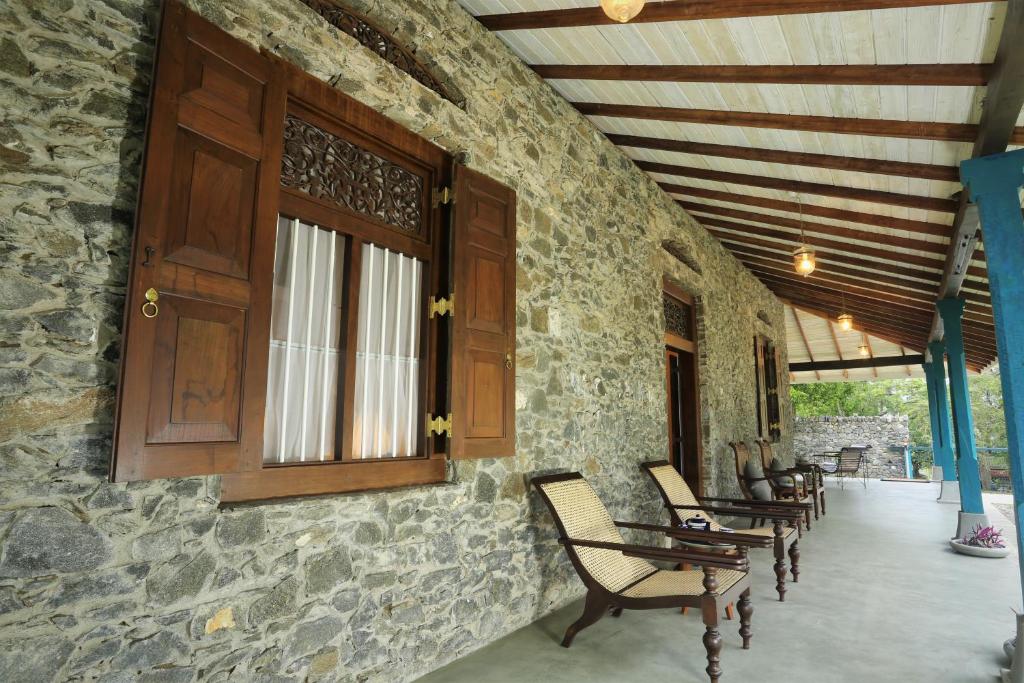 康提Stone Cottage的门廊设有摇椅和木门