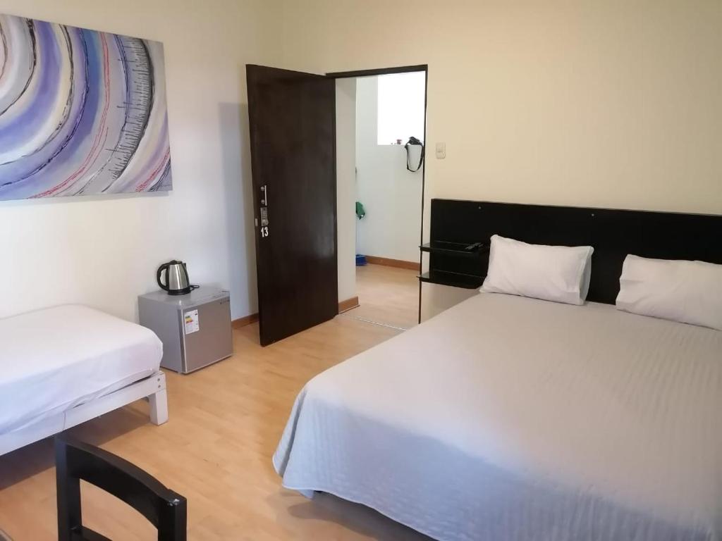 利马Miraflores Rooms的一间卧室设有两张床,一扇门通往房间