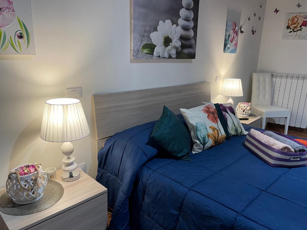 斯波莱托Via G Mameli 94 ZTL zona tempo libero的一间卧室配有一张蓝色的床和两盏灯。