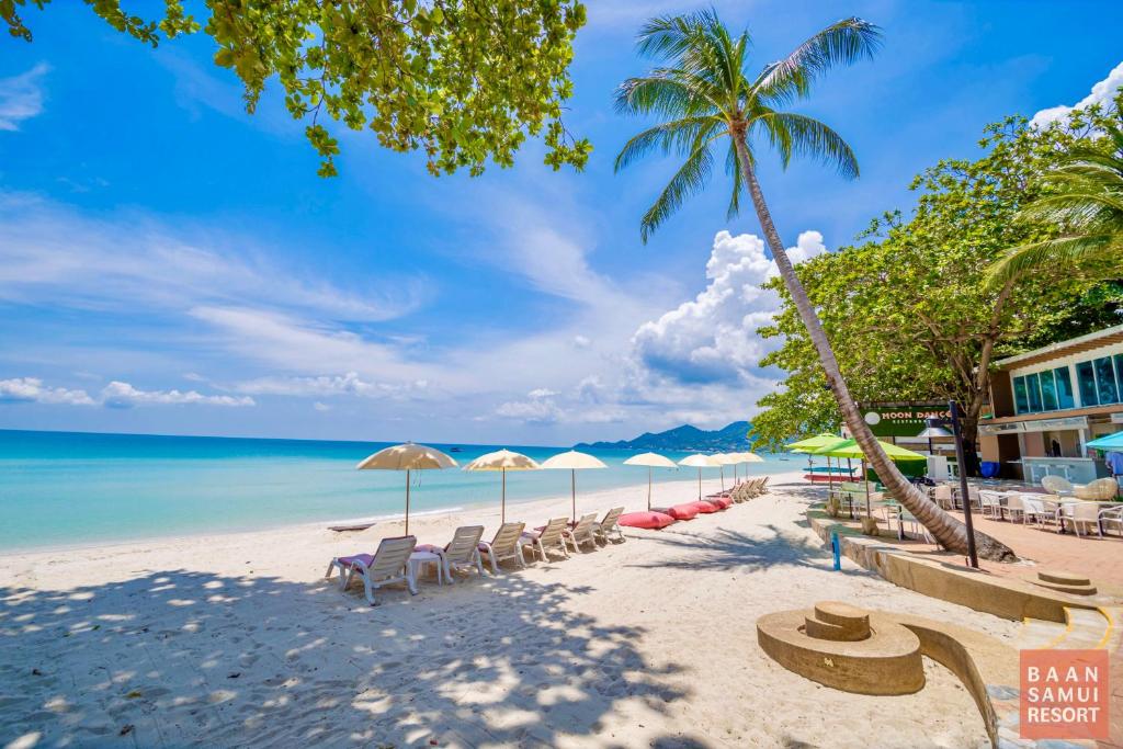 查汶Baan Samui Resort - SHA Extra Plus的海滩上设有椅子和遮阳伞,还有大海