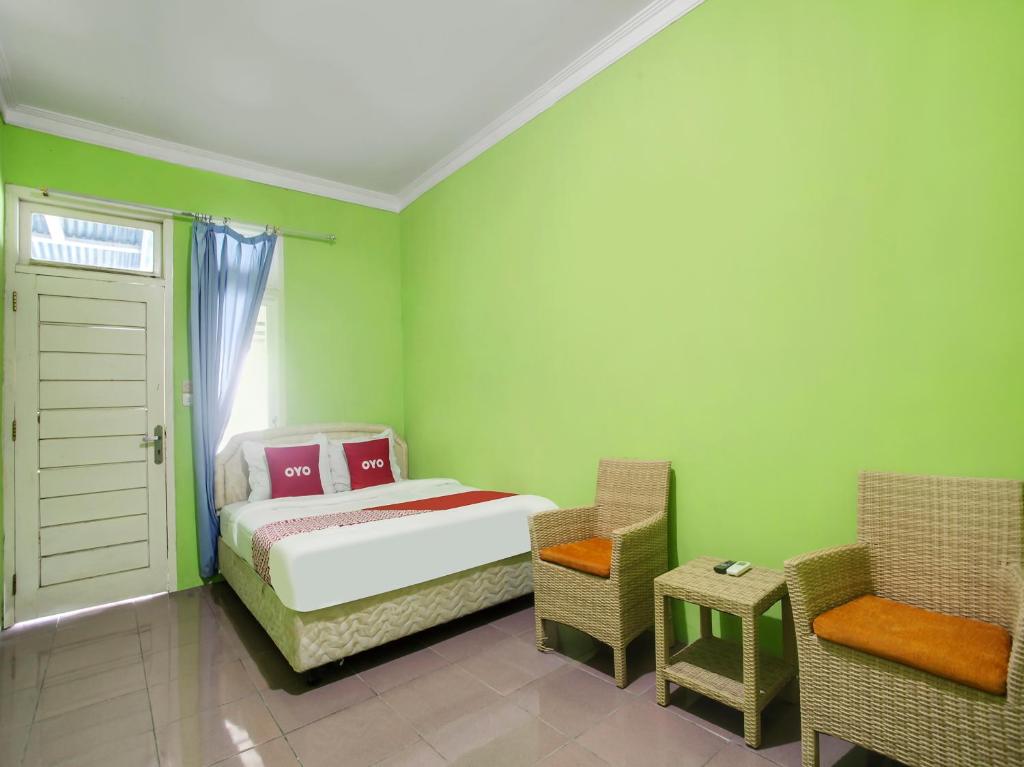 班达楠榜OYO 91005 Cottage Putra Mutun Beach的一间小卧室,配有一张床和一把椅子