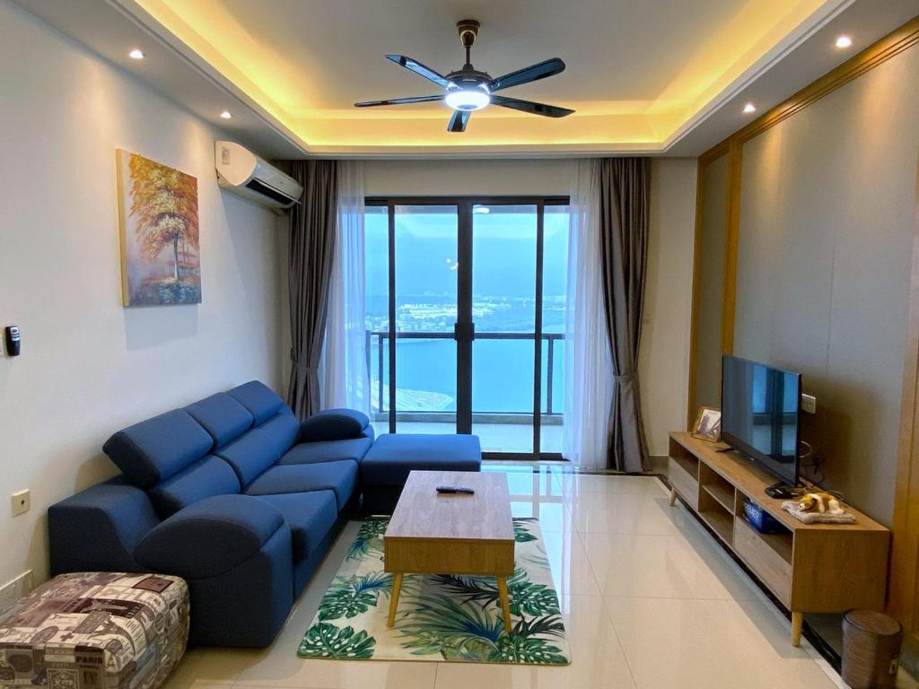 新山R&F Princess Cove JB Apartment Suites By SC Homestay的客厅配有蓝色的沙发和电视