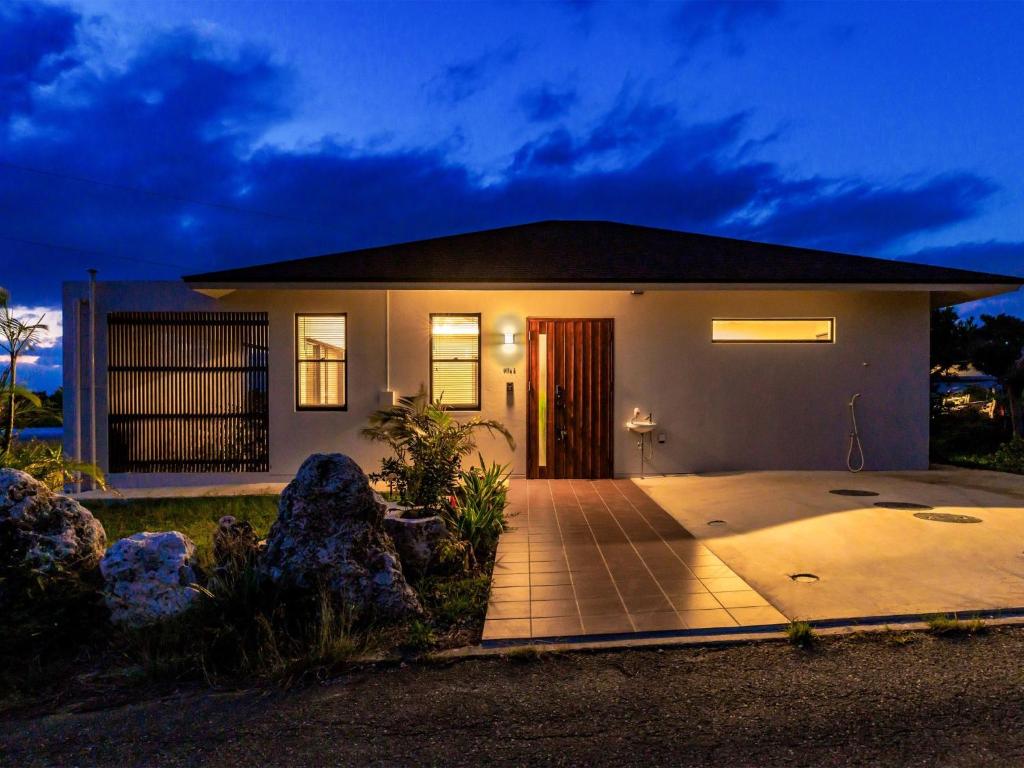 UechiGrace Villa Miyakojima - Vacation STAY 60494v的夜晚在前面有车道的房子