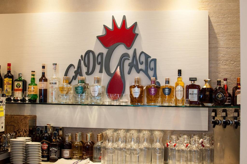 萨索马可尼Hotel Ca' di Gali的架子上装着许多瓶子和眼镜的酒吧