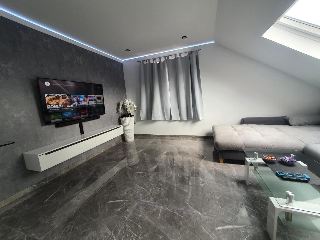 帕德博恩New York City Apartment的客厅配有沙发和墙上的电视
