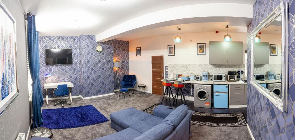 伯明翰Cosy Luxury Suite Jewellery Quarter - Birmingham的一间带蓝色沙发的客厅和一间厨房