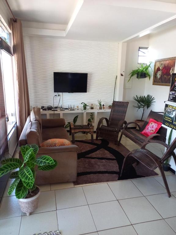 Colinas Do SulPousada Adorno的客厅配有沙发、椅子和平面电视。