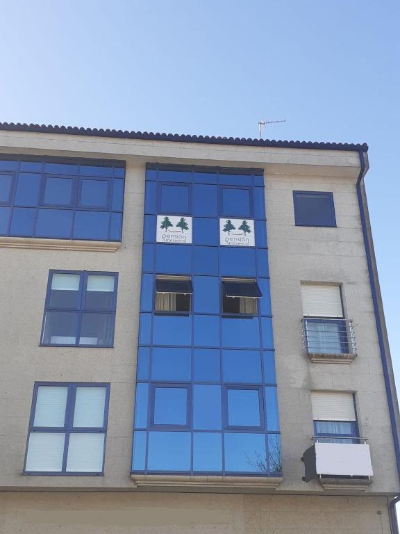 欧德鲁佐Pension Ameneiral的一座高高的建筑,上面有蓝色的玻璃窗