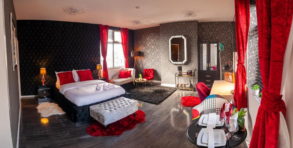 伯明翰Opulent 1 Bedroom Cosy Suite的一间卧室配有床,另一间卧室配有红色窗帘