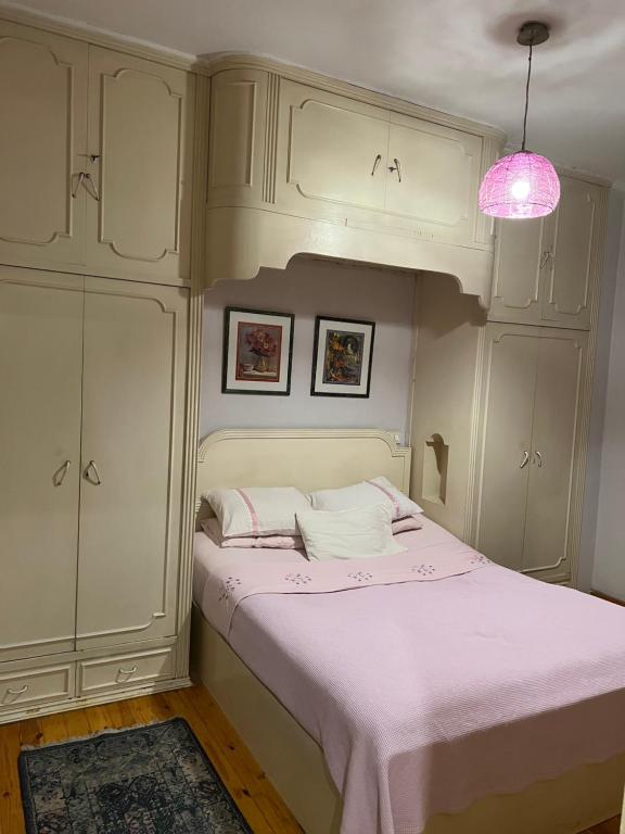开罗very comfortable and cozy的卧室配有白色的床和粉红色的灯