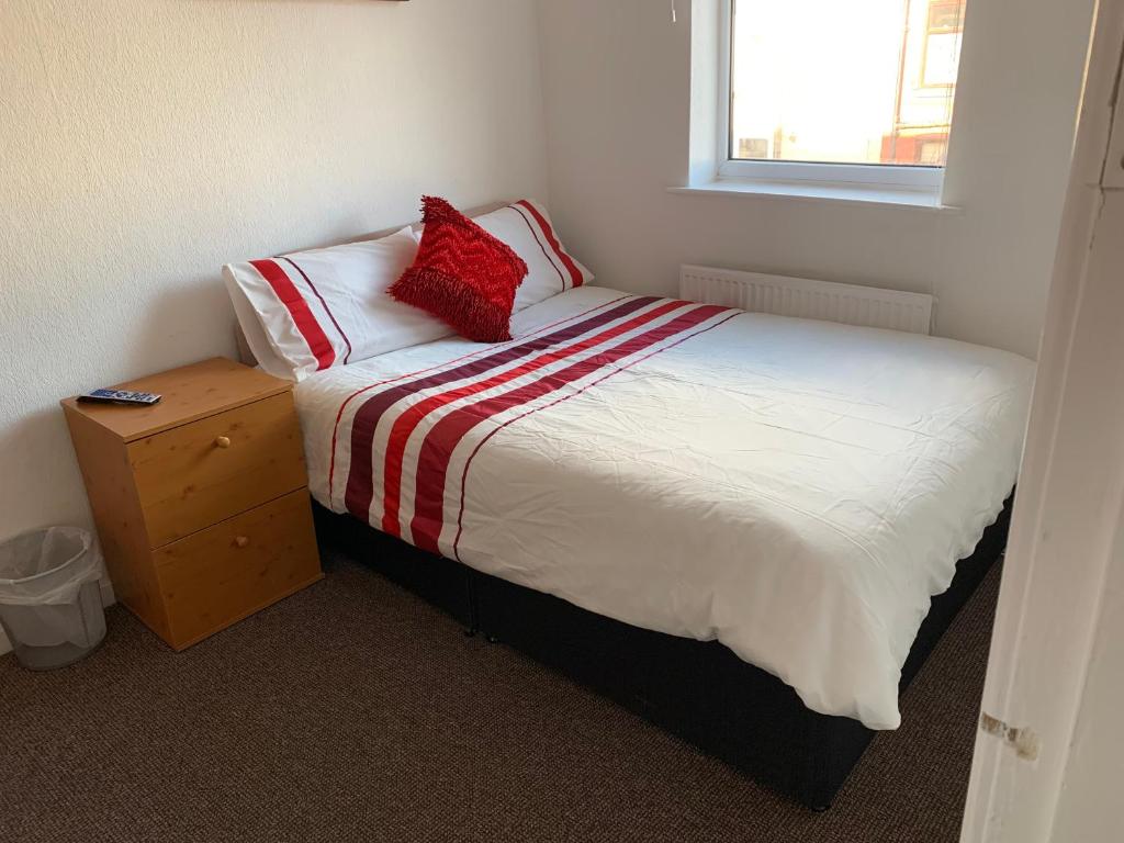 利Starlight Self Service Accommodation的一间卧室配有一张红色枕头的床