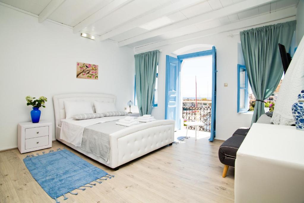 卡利诺岛spongkalyA apartment II的白色的卧室设有白色的床和窗户。