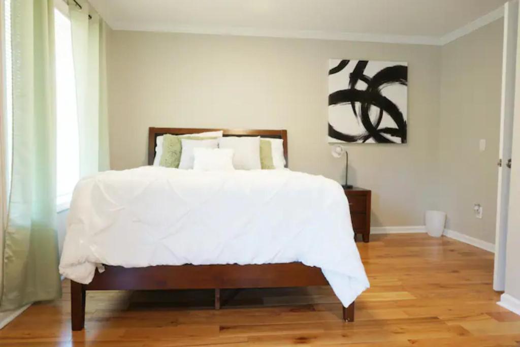 亚特兰大Atlanta Unit 1 Room 1 - Peaceful Private Master Bedroom Suite with Private Balcony的一间卧室配有一张铺有木地板的白色床单。