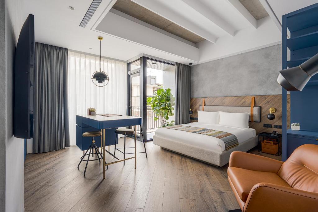 台北The Denizen 真寓的配有一张床和一张书桌的酒店客房