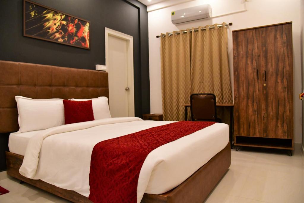 迈索尔Xcel Luxury Hotel Apartments-Home Living Redefined的一间卧室配有一张带红色毯子的大床