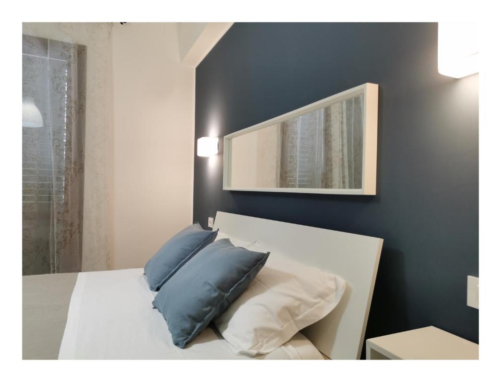法维尼亚纳MG CASA VACANZE FAVIGNANA的一间卧室配有白色床和蓝色枕头