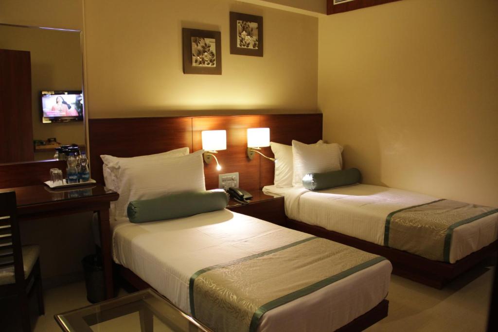 奥兰加巴德绿橄榄酒店的酒店客房,设有两张床和镜子