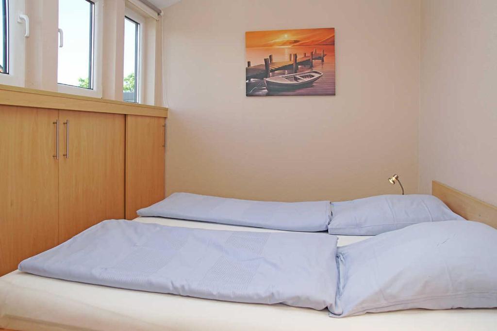 库克斯港Wohnung 10的卧室配有两张床,墙上挂着一幅画