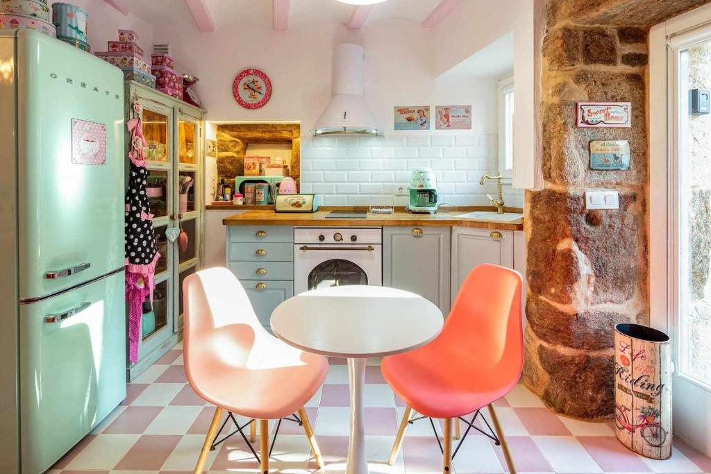 科尔库维翁La Suite Años 50 La casa Barbie Bañera chimenea的厨房配有桌子和橙色椅子