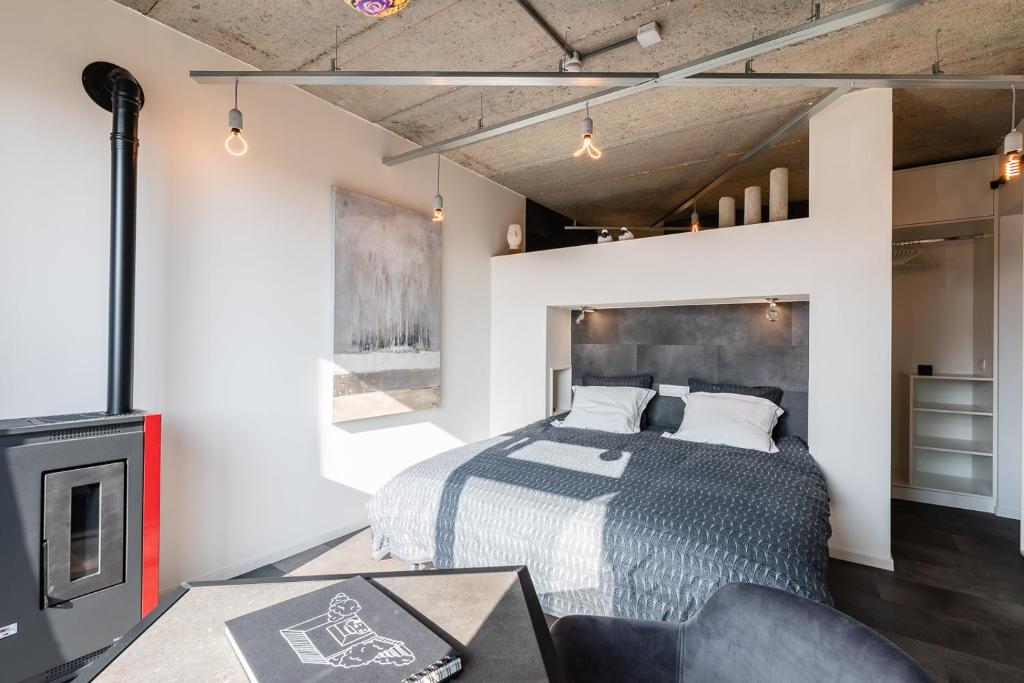 特镇Le Garage的一间卧室配有一张床和一个壁炉