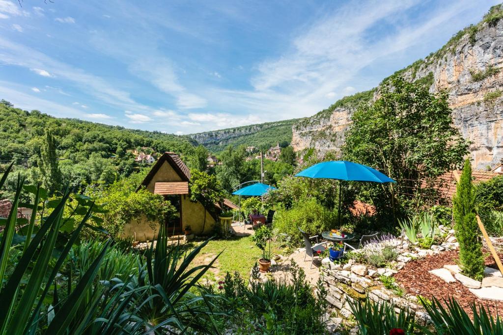 CabreretsGîtes Un Jardin dans la Falaise的山前带蓝伞的花园